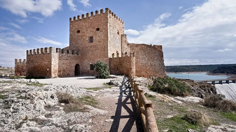 Vista frontal de fortaleza medieval con torres y murallas