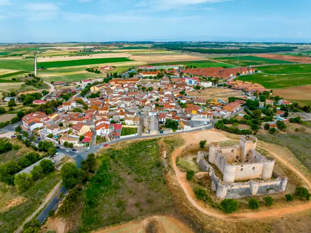 Vista aérea del pueblo con casas de piedra y calles estrechas rodeadas de naturaleza.