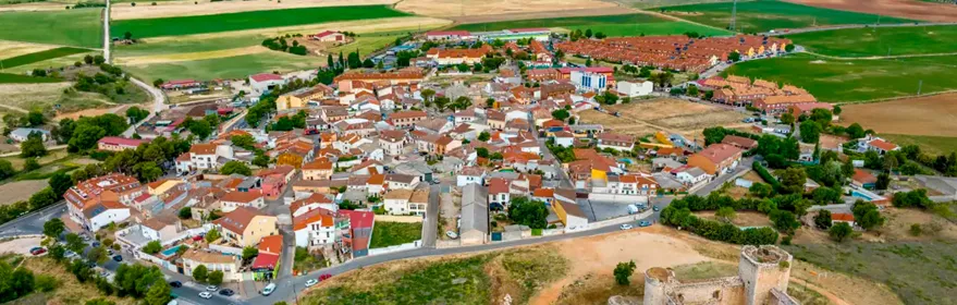 Vista aérea del pueblo con casas de piedra y calles estrechas rodeadas de naturaleza.