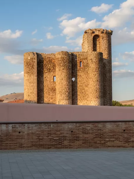 Estructura fortificada tras un muro bajo cielo despejado.
