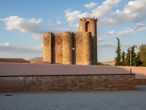 Estructura fortificada tras un muro bajo cielo despejado.