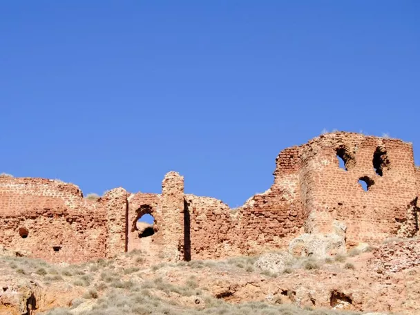 Muralla de piedra en ruinas sobre una colina bajo cielo despejado
