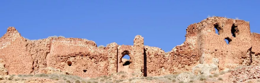 Muralla de piedra en ruinas sobre una colina bajo cielo despejado