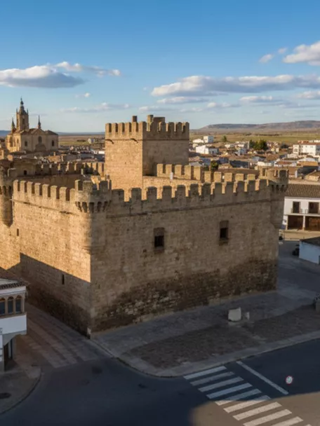 Vista aérea de castillo de piedra junto al pueblo