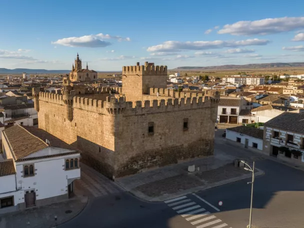 Vista aérea de castillo de piedra junto al pueblo