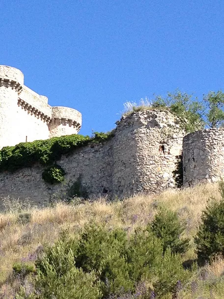Castillo medieval de piedra sobre colina en paisaje manchego