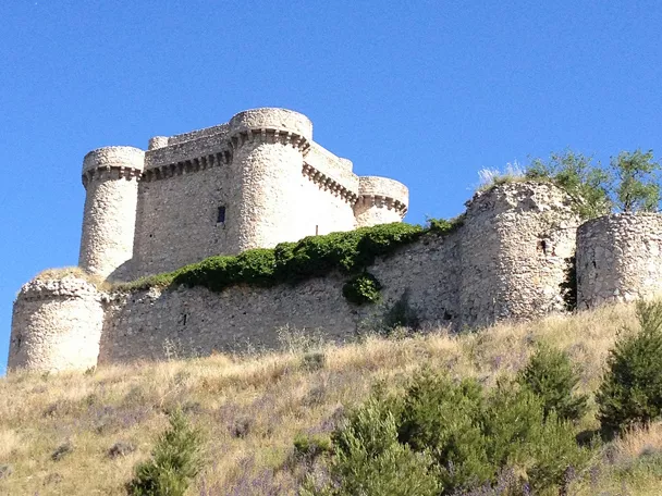 Castillo medieval de piedra sobre colina en paisaje manchego