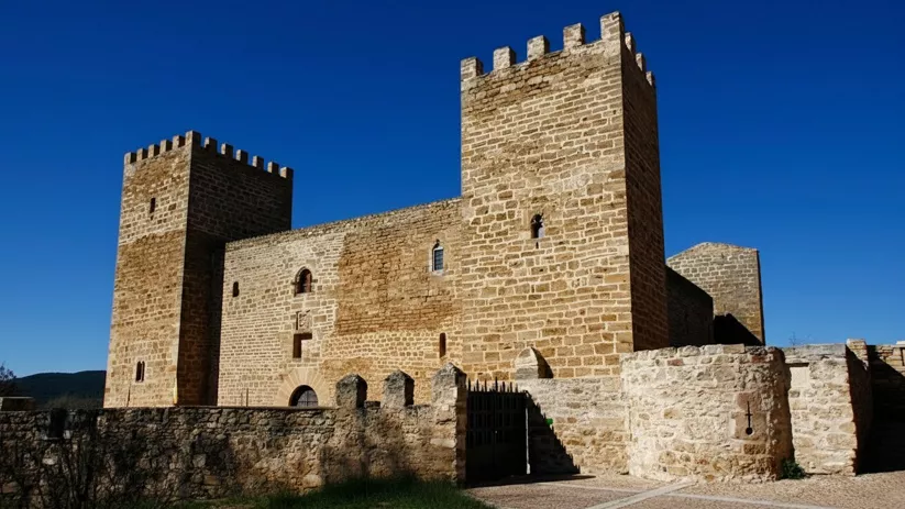 Fortaleza de piedra con torres cuadradas y muralla.