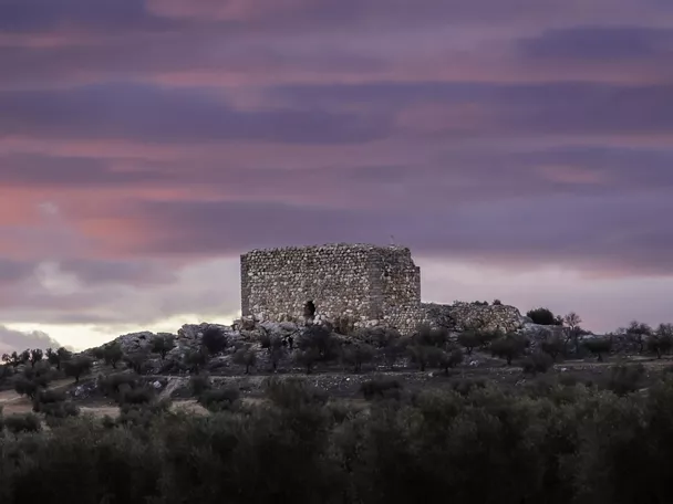 Torre de piedra sobre una colina al atardecer