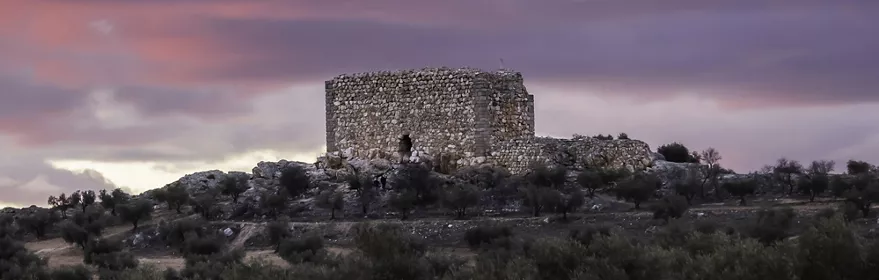 Torre de piedra sobre una colina al atardecer