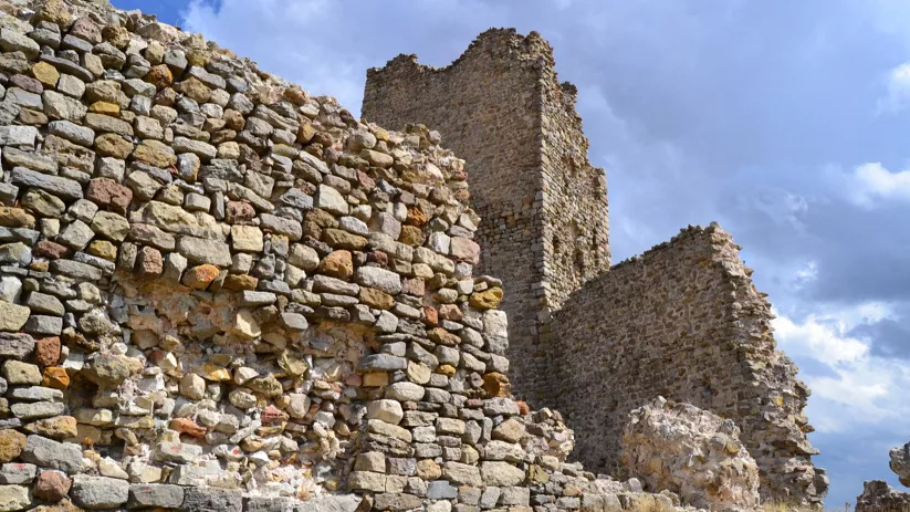 Muros de piedra bajo cielo nublado.