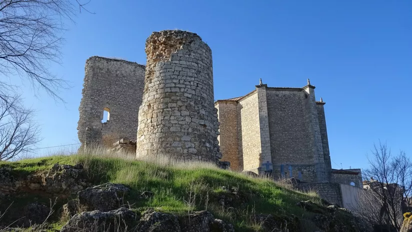 Torre circular en ruinas sobre una colina.