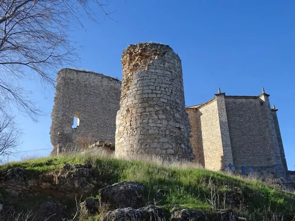 Torre circular en ruinas sobre una colina.