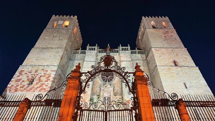 Fachada fortificada con torres al anochecer