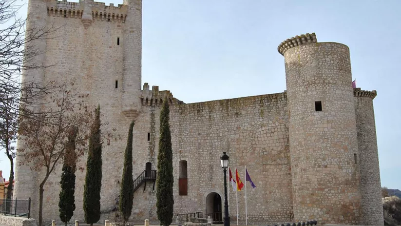 Castillo de piedra con torres circulares.