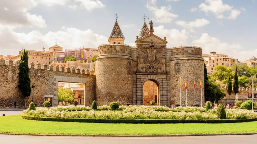 Puerta monumental de muralla con jardines y torres de piedra