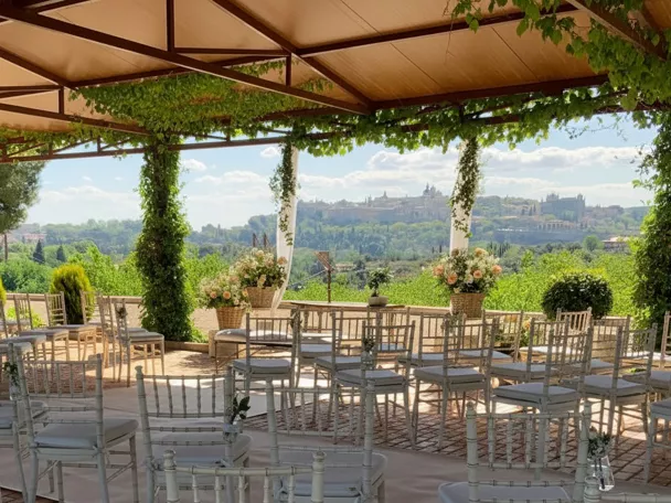 Espacio para ceremonia al aire libre con sillas y pérgola cubierta de vegetación.