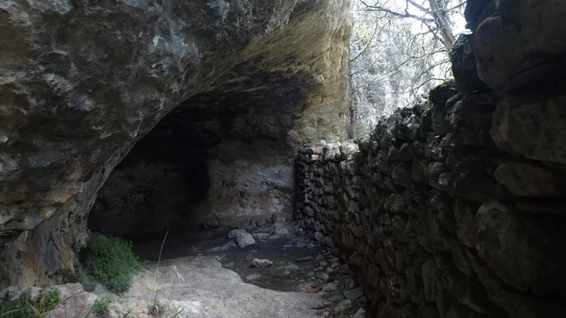 Pasadizo rocoso con muro de piedra.