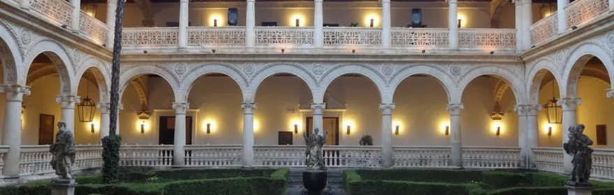 Claustro renacentista con arcos y jardín central.