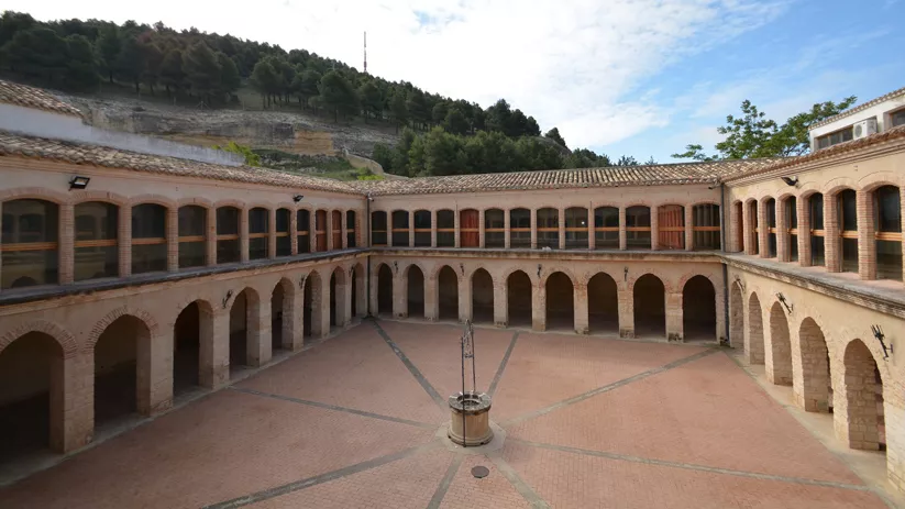 Claustro porticado con pozo central y arquerías.