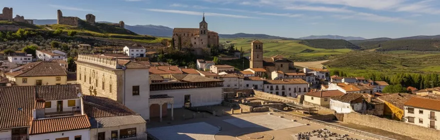 Vista panorámica de conjunto histórico con plaza elevada y paisaje verde