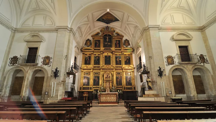 Interior monumental con retablo dorado.