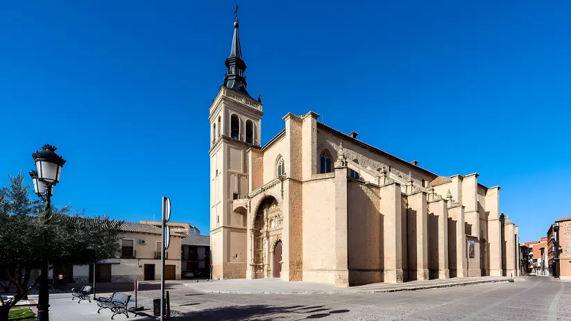 Vista lateral de gran iglesia de piedra en plaza vacía