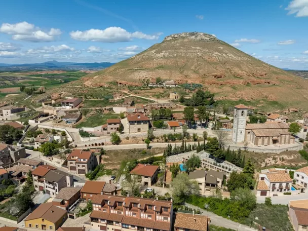 Vista aérea de pueblo junto a colina aislada.