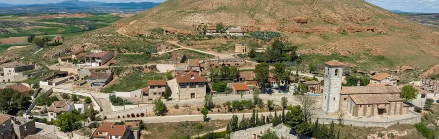 Vista aérea de pueblo junto a colina aislada.