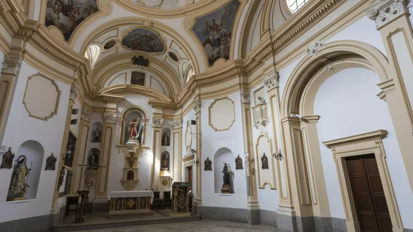 Interior de iglesia con cúpula decorada y altar.