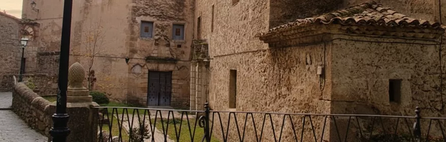 Fachada de convento en calle empedrada al atardecer.