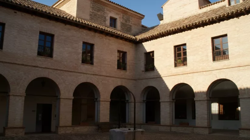 Claustro de ladrillo con arcos de medio punto y pozo central.