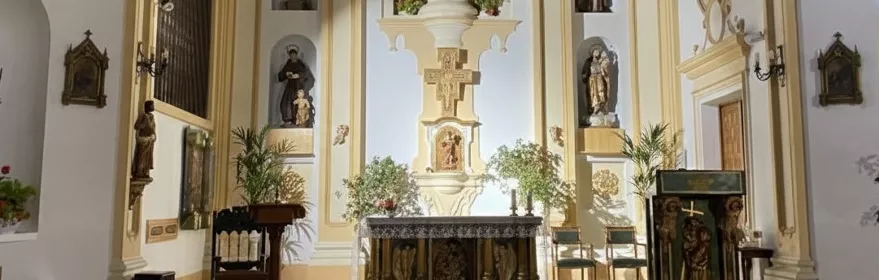 Interior de iglesia con altar y retablos laterales.