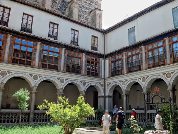 Patio claustral con arcos, galerías acristaladas y jardín central
