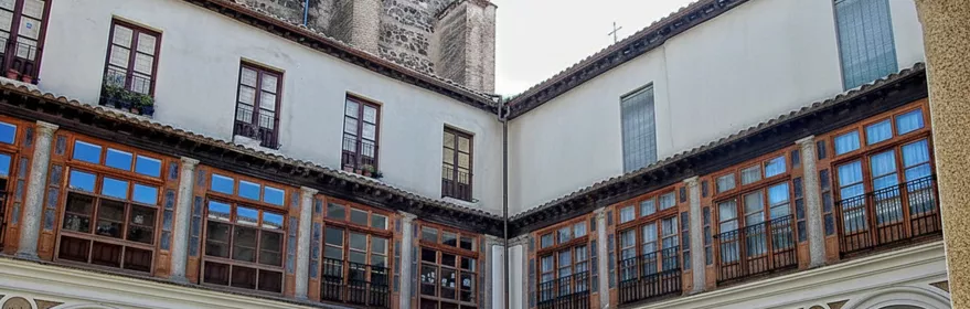 Patio claustral con arcos, galerías acristaladas y jardín central
