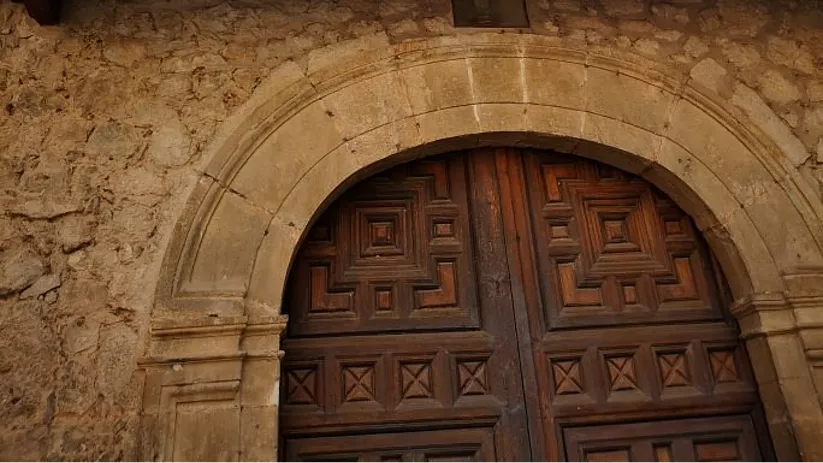 Puerta monumental de convento de piedra.
