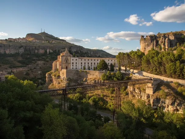 Convento sobre acantilado con puente metálico