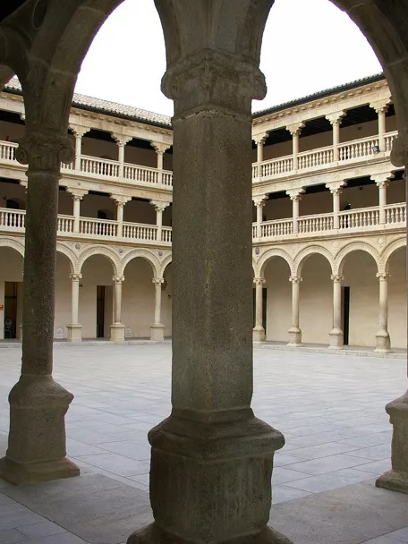 Claustro de piedra con columnas y arcos alrededor de un patio interior.
