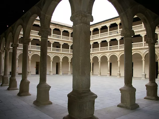 Claustro de piedra con columnas y arcos alrededor de un patio interior.