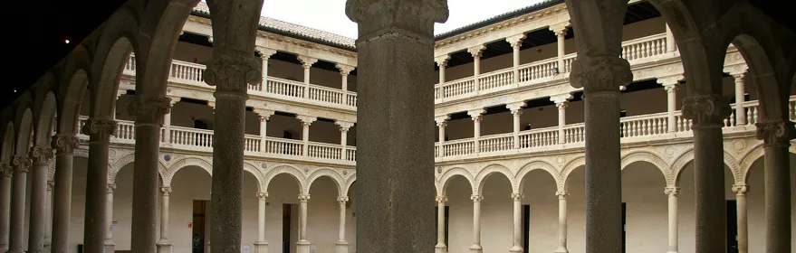 Claustro de piedra con columnas y arcos alrededor de un patio interior.