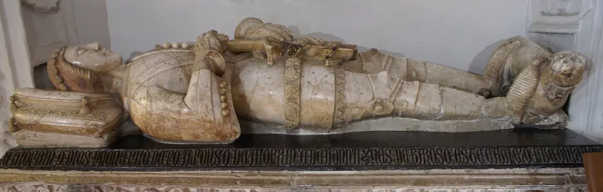 Sepulcro de mármol con figura yacente sobre base esculpida con relieves.