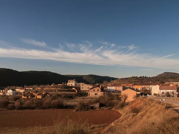 Vista general de núcleo rural con campos y colinas alrededor