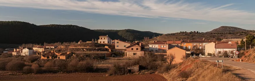 Vista general de núcleo rural con campos y colinas alrededor