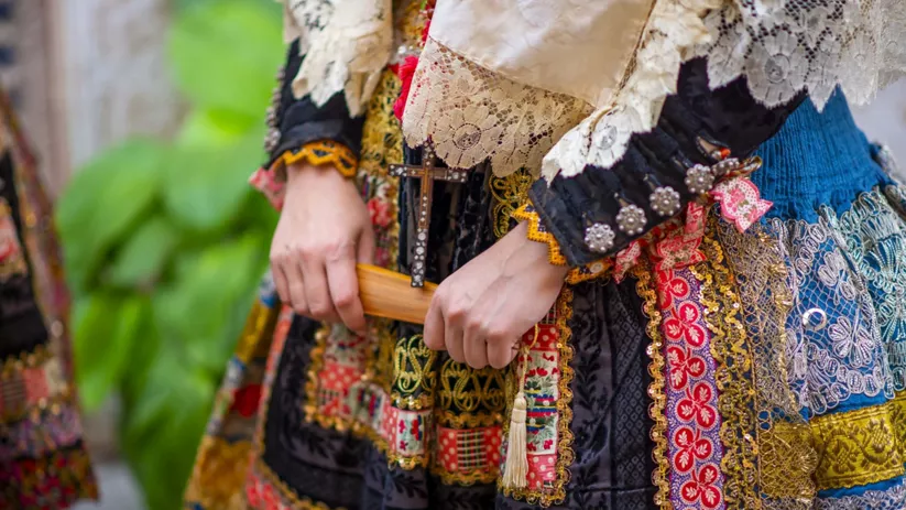 Detalle de traje tradicional bordado con encajes y adornos