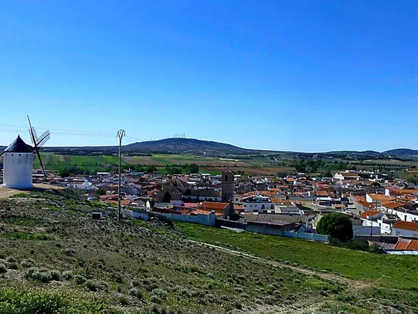 Vista panorámica de un pueblo con molino de viento en una colina.