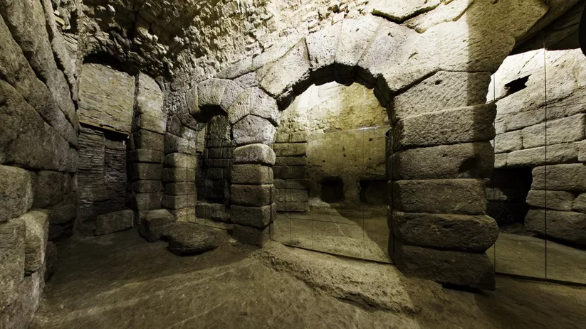 Sala subterránea de piedra con arcos y columnas antiguas