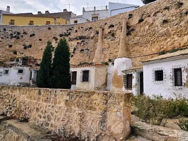 Conjunto de casas cueva excavadas en una ladera rocosa con muros encalados.
