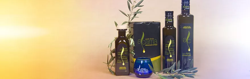 Botellas y envases de aceite de oliva virgen extra junto a ramas de olivo