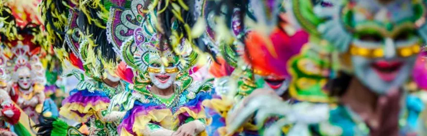 Personas desfilando con trajes coloridos y máscaras decoradas