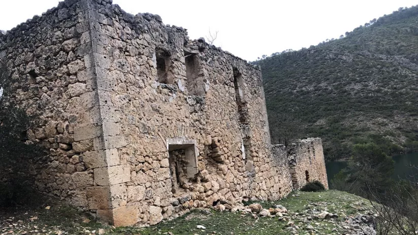Construcción de piedra en ruinas junto a un entorno natural